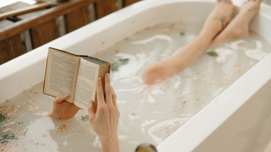 women in bath relaxed with book 