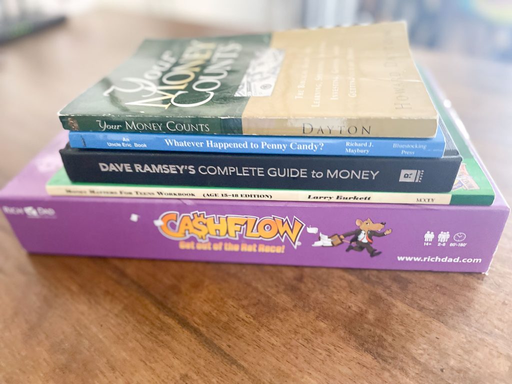stack of finance books and a game