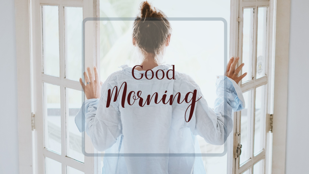 woman looking out open doors with good morning written