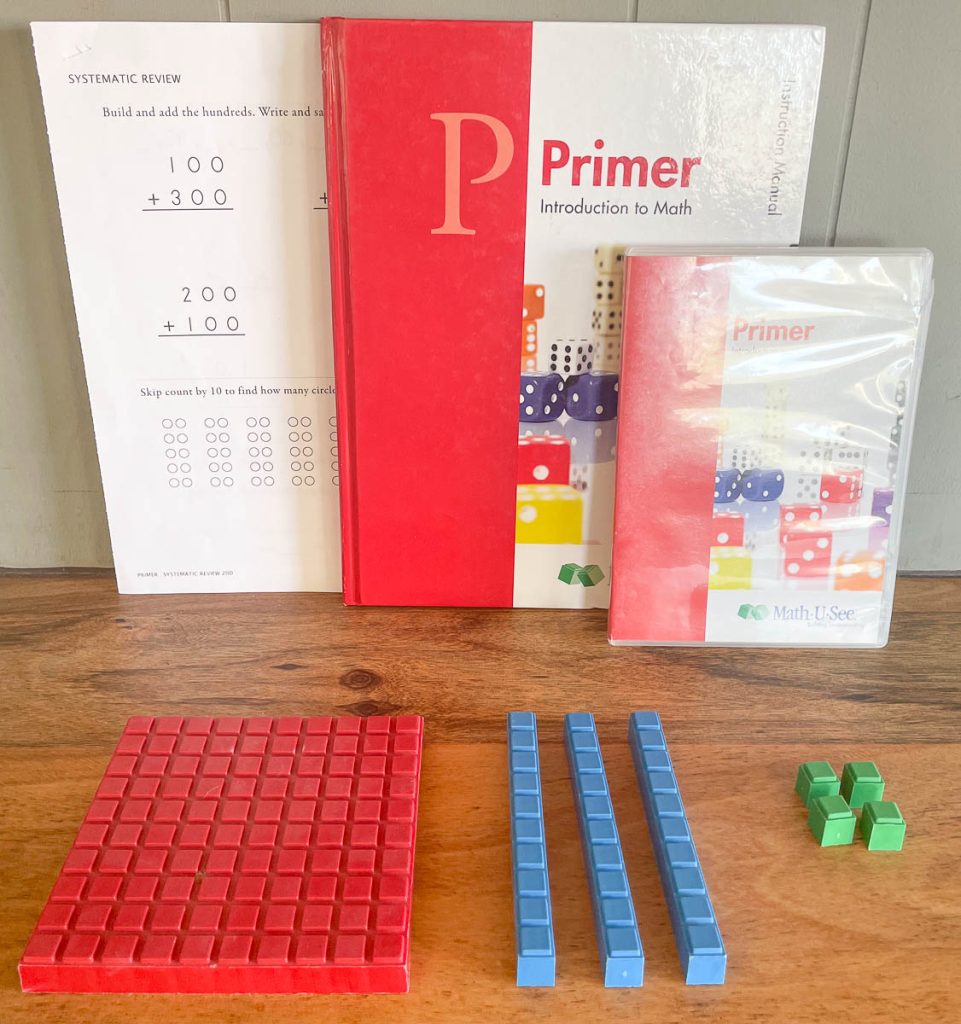 A math curriculum for a younger child along with a book, worksheet, DVD, and some blocks.