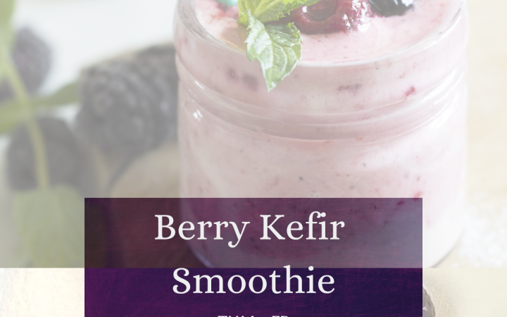 A smoothie in a jar with a straw and berries next to it.