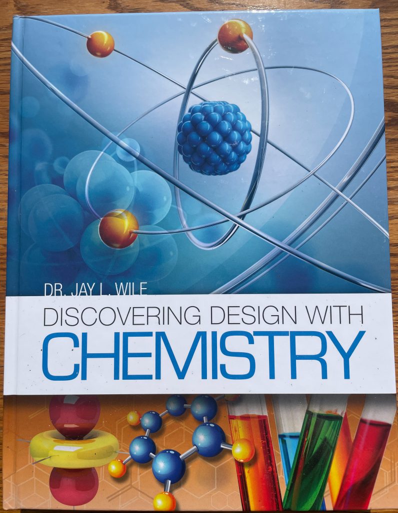 A high school science book laying closed on a table.